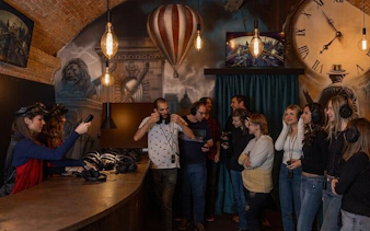 Visitors at Time Machine Budapest immersive exhibition with VR headsets and historical decor.