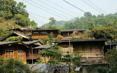 Mae Kham Pong Village traditional wooden houses surrounded by lush greenery, Chiang Mai.