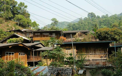 Mae Kham Pong Village traditional wooden houses surrounded by lush greenery, Chiang Mai.