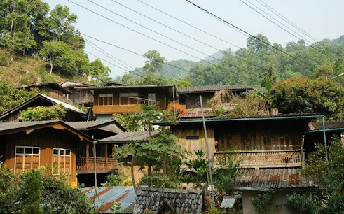 Mae Kham Pong Village traditional wooden houses surrounded by lush greenery, Chiang Mai.