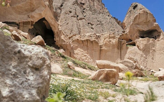 Rock formations and caves in Cappadocia, Turkey, under a clear blue sky.