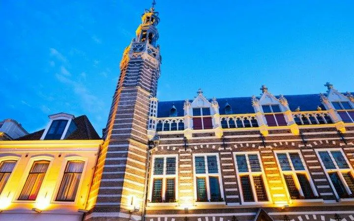 Alkmaar historic building with illuminated facade during self-guided audio walking tour.