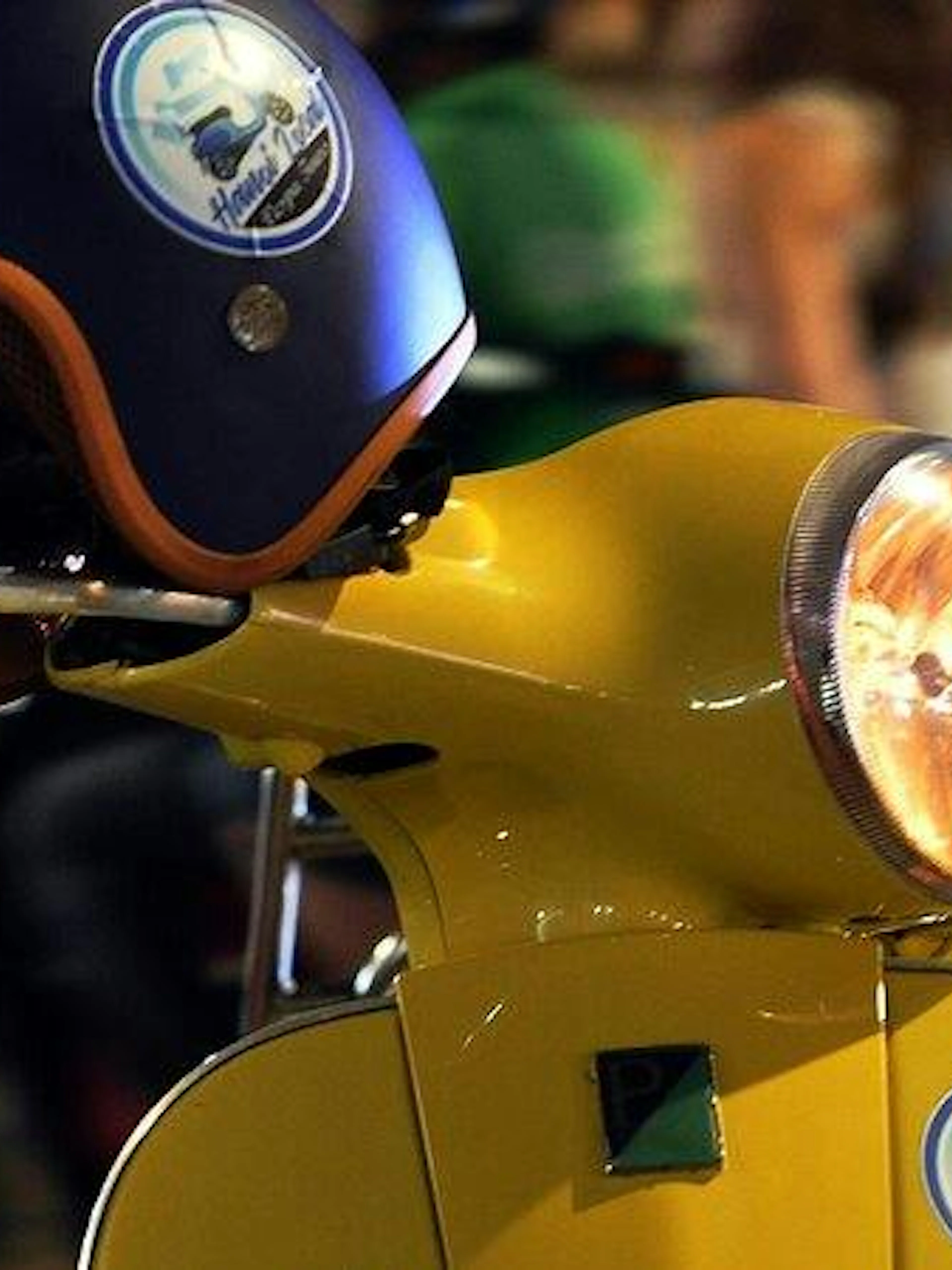 Yellow Vespa with helmet on Hanoi street, capturing night tour ambiance.