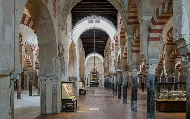 Mosque-Cathedral of Cordoba interior with arches and display cases.