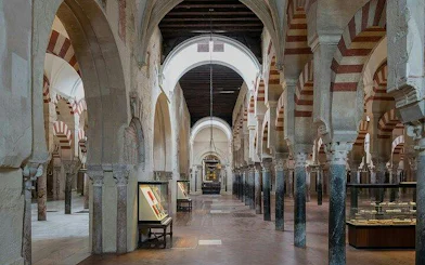 Mosque-Cathedral of Cordoba interior with arches and display cases.
