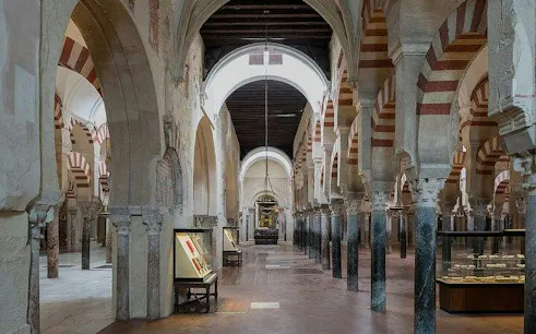 Mosque-Cathedral of Cordoba interior with arches and display cases.