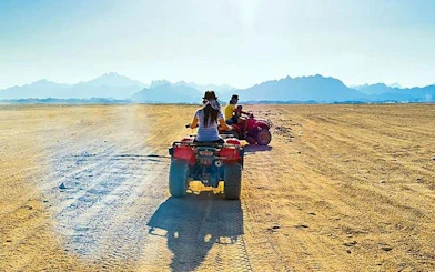 Quad biking adventure in Hurghada desert with distant mountains.