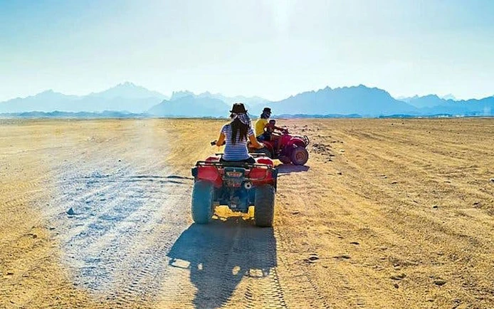 Quad biking adventure in Hurghada desert with distant mountains.