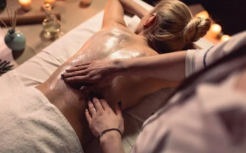 Hammam massage in 16th-century Marrakesh bathhouse with candles and oils.