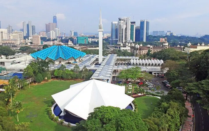 National Mosque of Malaysia with Kuala Lumpur skyline in the background.