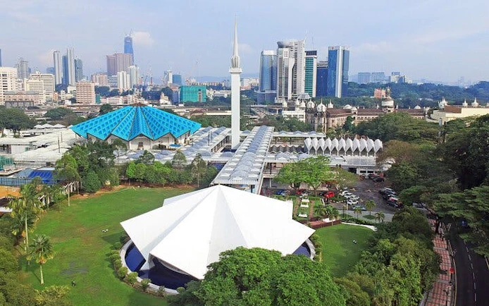 National Mosque of Malaysia with Kuala Lumpur skyline in the background.