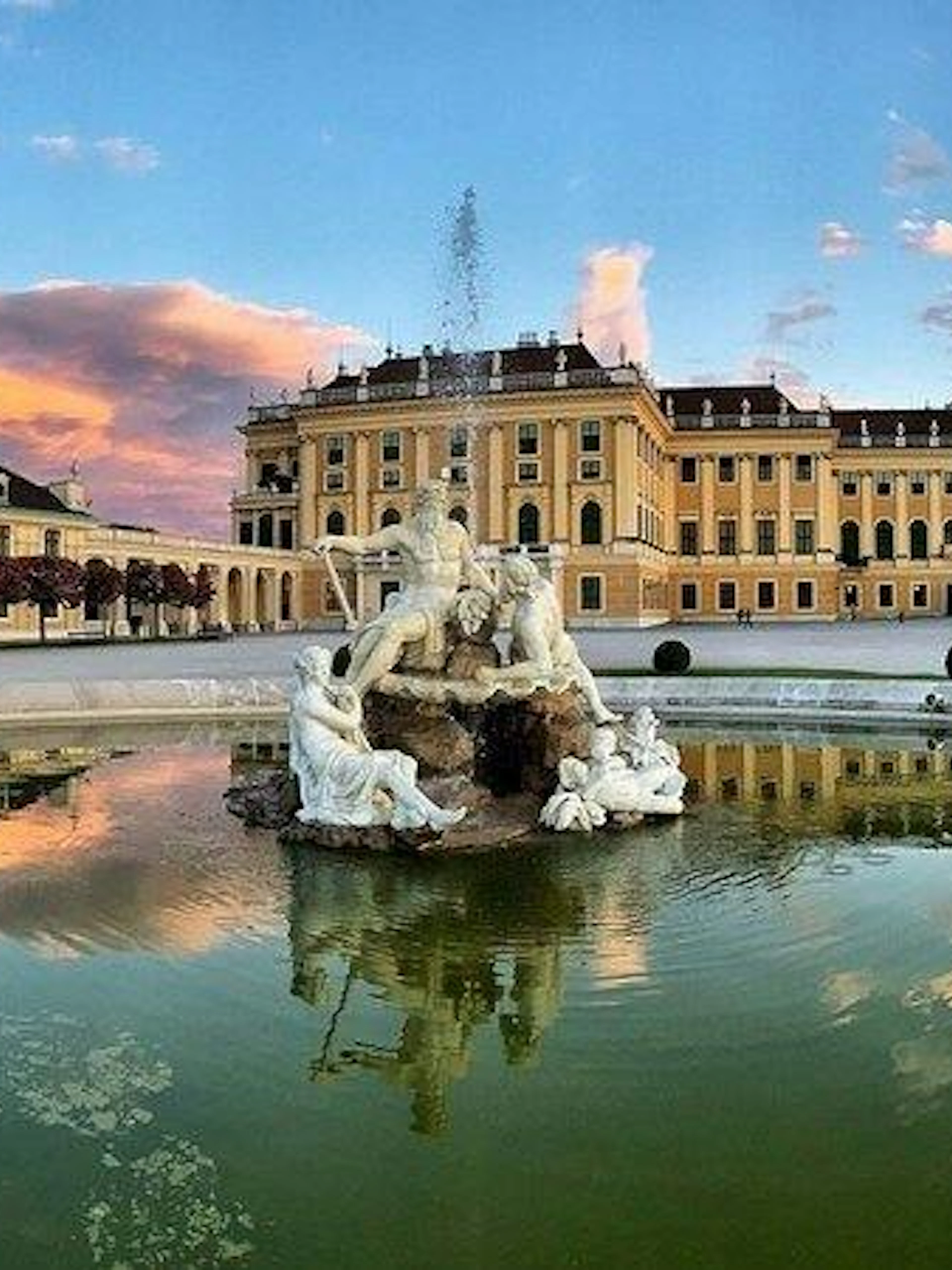 Schönbrunn Palace with Neptune Fountain at sunset, Vienna.