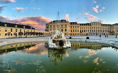 Schönbrunn Palace with Neptune Fountain at sunset, Vienna.