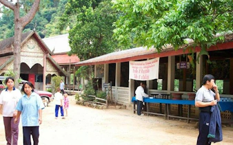 Mae Kham Pong Village scene with visitors and traditional Thai architecture, Chiang Mai.