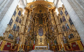 Ornate altar inside Mexico City Metropolitan Cathedral, featuring intricate gold detailing and religious artwork.