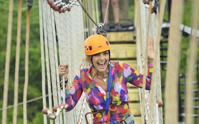 Person crossing a hanging bridge in Punta Cana zipline adventure.