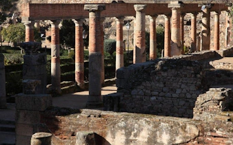Ancient Roman columns and ruins in Mérida, Spain, featured on a self-guided walking tour app.