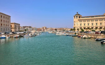Ortigia waterfront with boats and historic buildings, Siracusa, Italy.