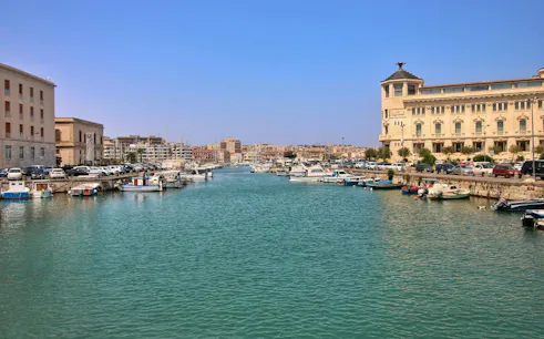 Ortigia waterfront with boats and historic buildings, Siracusa, Italy.