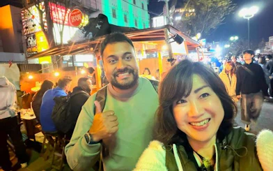 Nakasu food stall tour in Fukuoka with people enjoying street food at night.