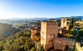 Alhambra fortress overlooking Granada cityscape on a sunny day.