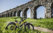 Bicycle near ancient Roman aqueduct on Appian Way, Rome.