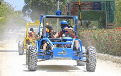 Off-road buggies driving on a dirt path in Punta Cana, part of an adventure tour.