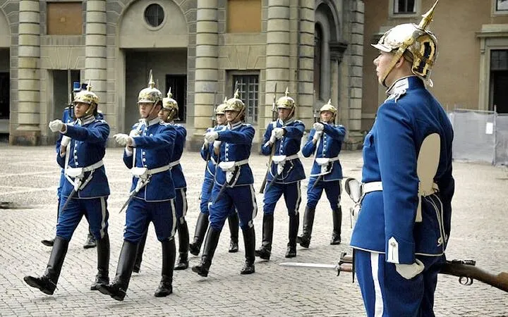 Royal guards marching in blue uniforms at Stockholm Palace, Sweden.