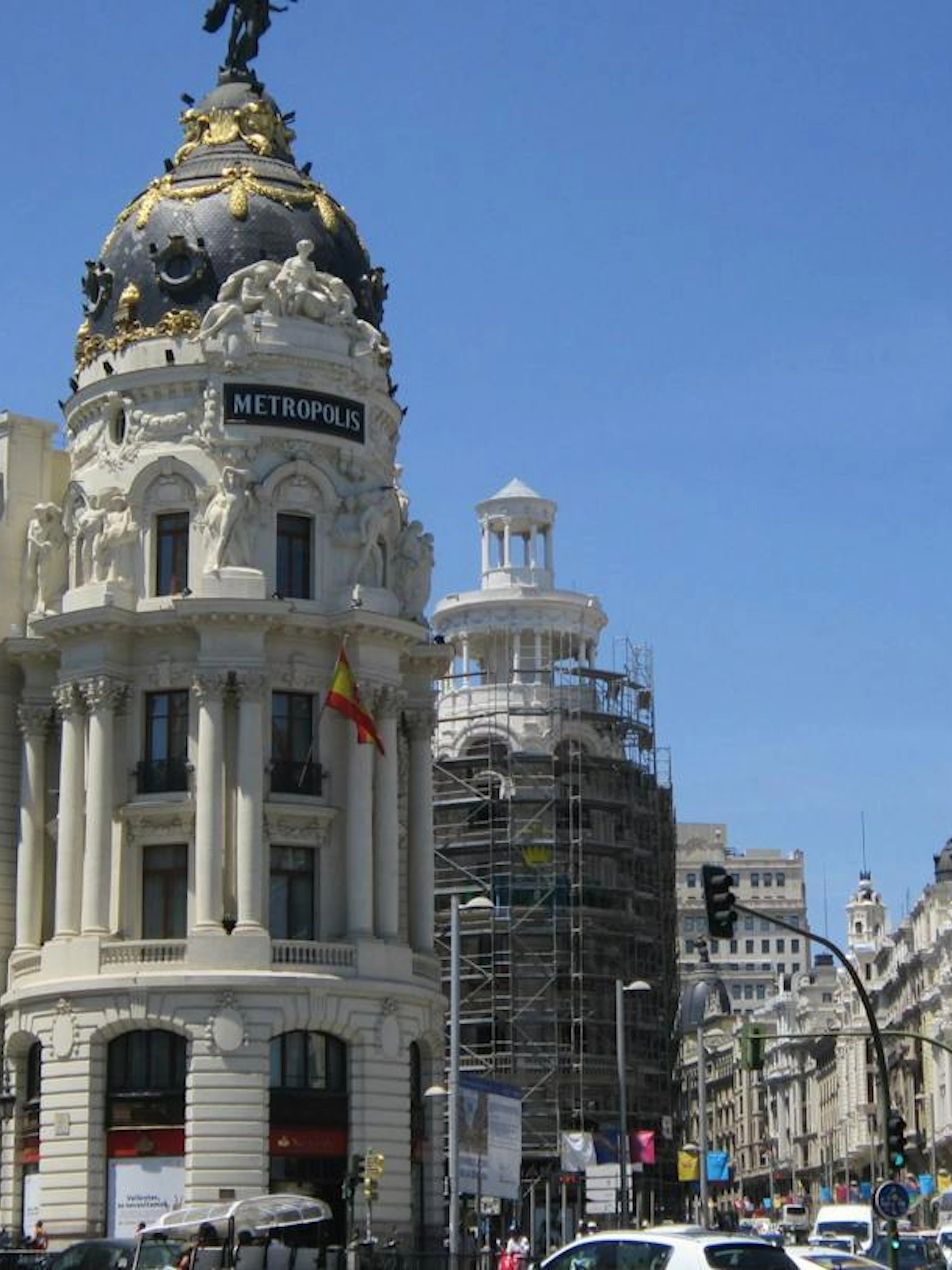 Metrópolis Building on Gran Vía, Madrid, with surrounding architecture and traffic.