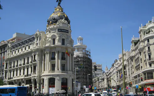 Metrópolis Building on Gran Vía, Madrid, with surrounding architecture and traffic.