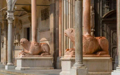 Stone lion sculptures at the entrance of Cremona Cathedral, Italy.