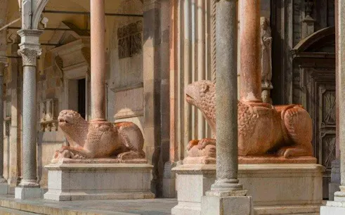 Stone lion sculptures at the entrance of Cremona Cathedral, Italy.