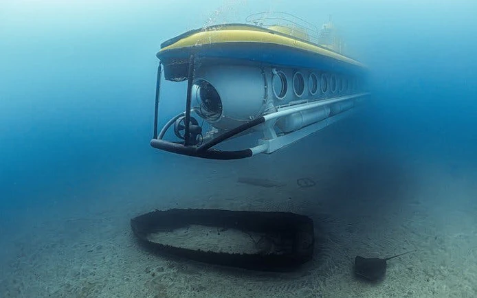 Submarine exploring underwater near shipwreck, Tenerife tour.