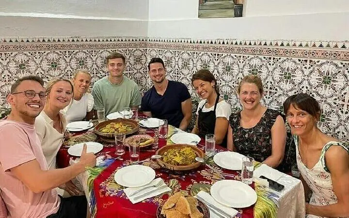Group enjoying Moroccan meal during cooking class in Marrakesh.
