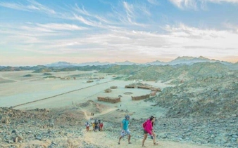 Tourists hiking in the desert landscape during a sunrise buggy safari in Sharm El Sheikh.