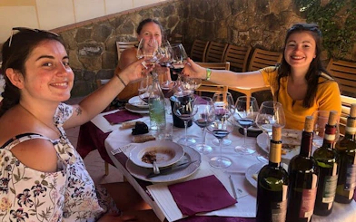 Women enjoying wine tasting during Chianti Vespa tour with Tuscan lunch.