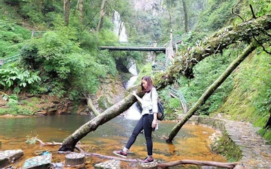 Visitor exploring Love Waterfall area in Sapa with lush greenery and a scenic bridge.
