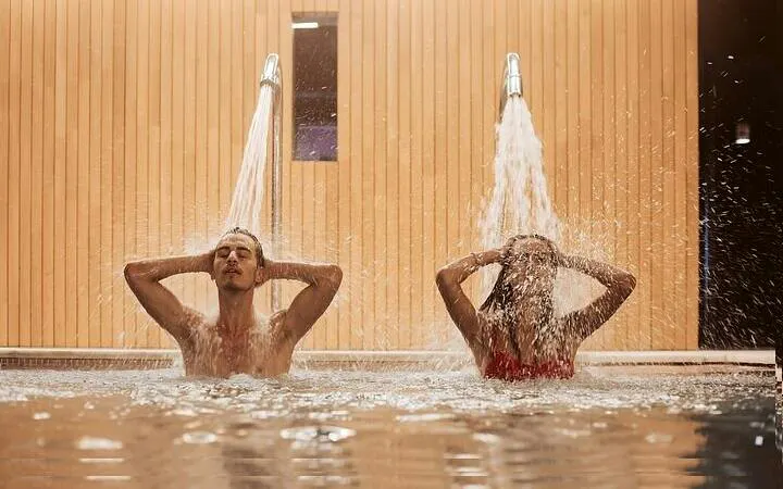 Couple enjoying water jets in a traditional Moroccan hammam, Marrakesh.