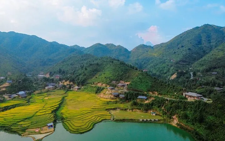 Sapa rice terraces and village near a lake with mountains in the background.