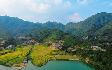 Sapa rice terraces and village near a lake with mountains in the background.