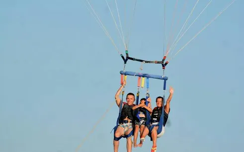 Parasailing over the Red Sea in Hurghada with three people enjoying the view.
