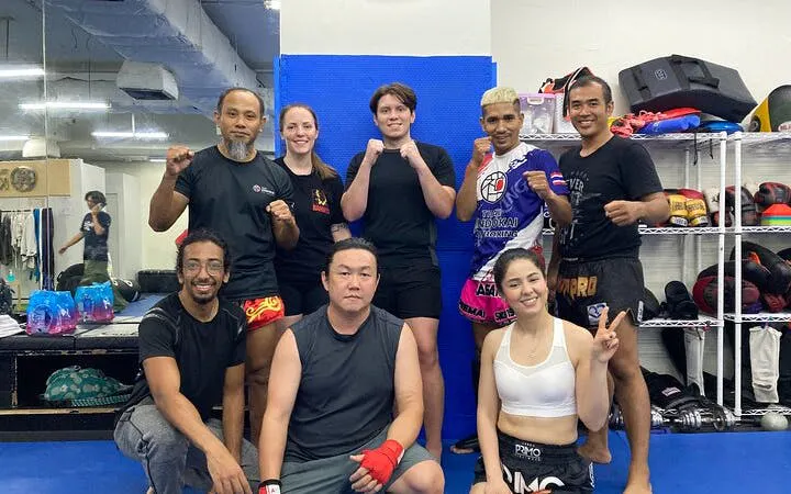 Muay Thai training group posing at a Bangkok gym, part of the Rajadamnern Stadium experience.