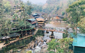 Sapa village landscape with bridges, waterfalls, and traditional houses on a motorbike sightseeing tour.
