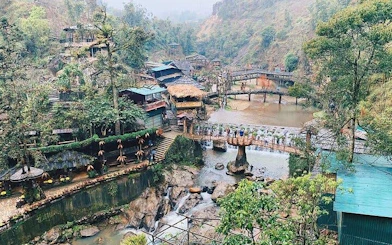 Sapa village landscape with bridges, waterfalls, and traditional houses on a motorbike sightseeing tour.