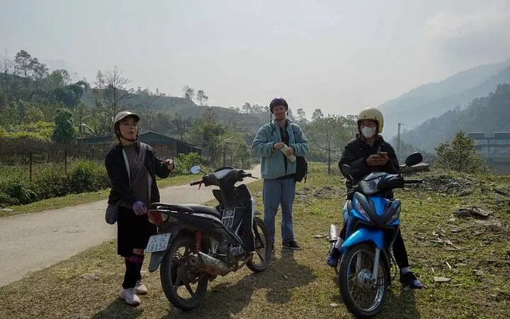 Motorbike riders in Sapa village landscape during scenic tour.
