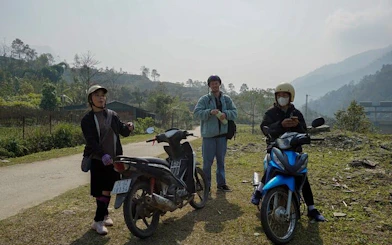 Motorbike riders in Sapa village landscape during scenic tour.