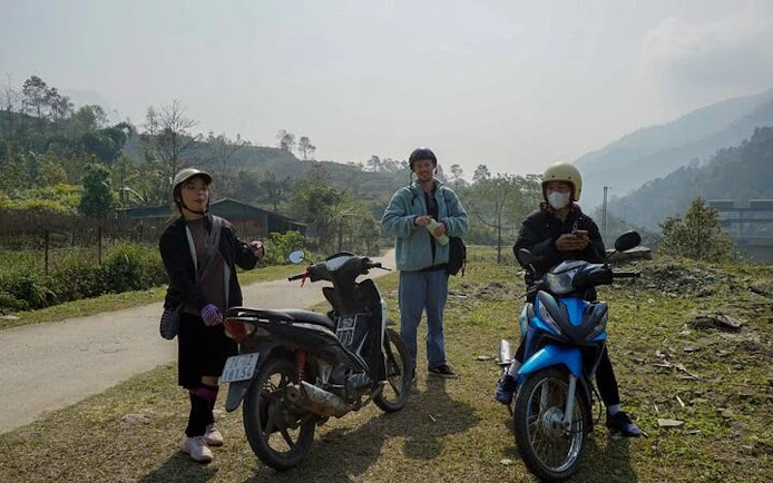 Motorbike riders in Sapa village landscape during scenic tour.