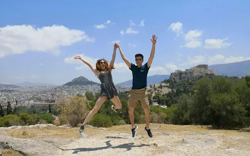 Jumping tourists with Acropolis view on Athens City Highlights Walking Tour.