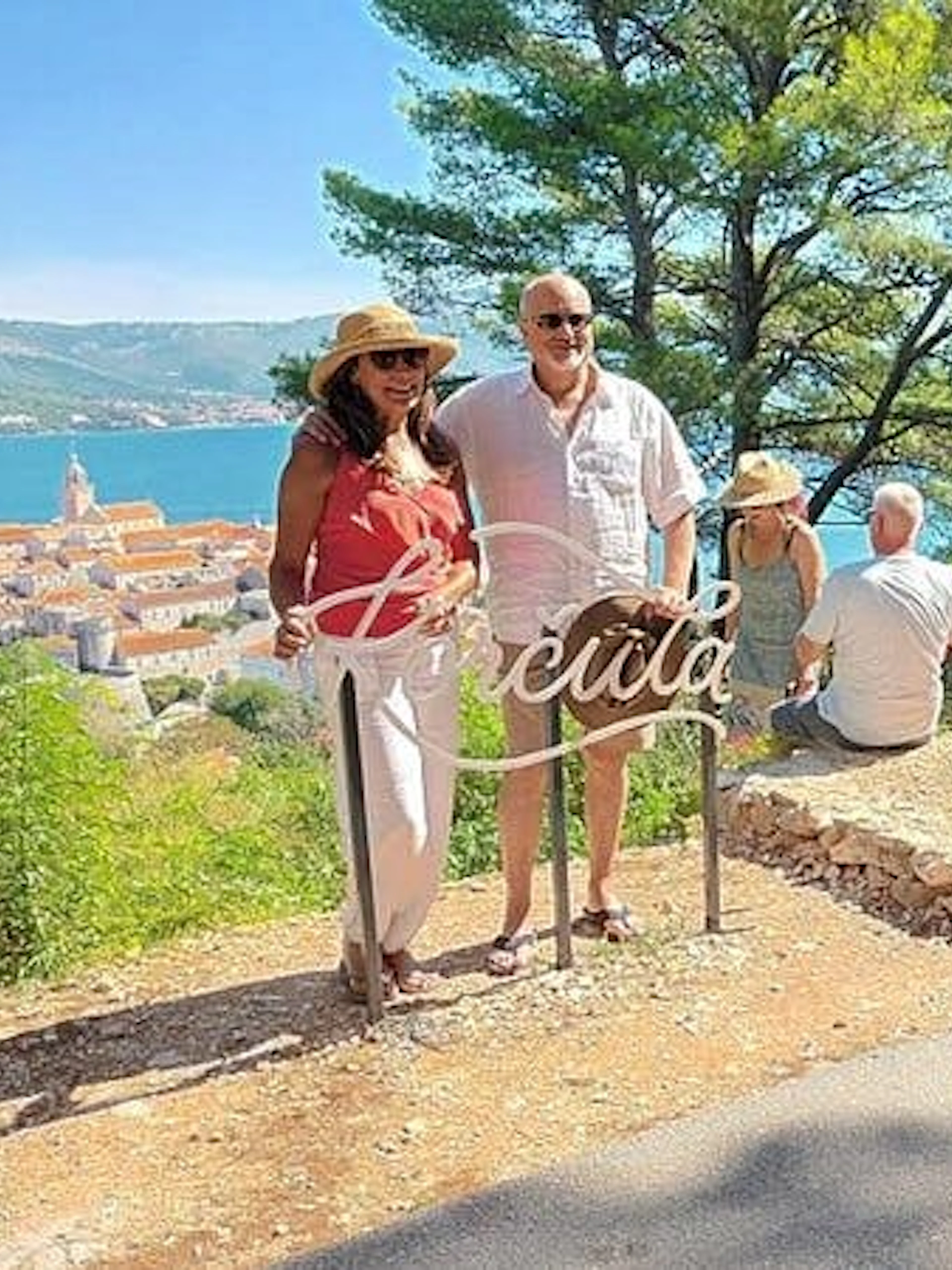 Tourists enjoying a scenic view of Korcula with a photographer capturing the moment.