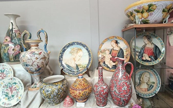 Florence artisan ceramics with painted plates and vases on display during workshop tour.